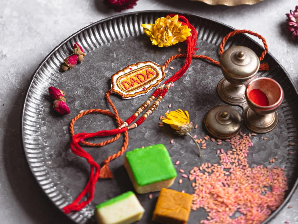 Rakhi and sweets in a plate to celebrate Raksha Bandhan